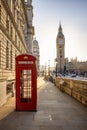 A classic, red telephone booth in front of the Big Ben clocktower in London Royalty Free Stock Photo