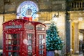 Red telephone booths in front of Christmas decorations lights in London, United Kingdom Royalty Free Stock Photo