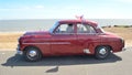 Classic Red Vauxhall Velox Motor being driven on seafront promenade.