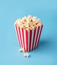 Classic red and white box of popcorn isolated on blue Royalty Free Stock Photo