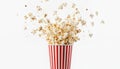Classic red, white striped cup overflows with popcorn, pieces bursting upwards in dynamic splash. Light, fluffy kernels create Royalty Free Stock Photo