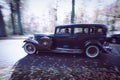 Classic retro Packard limousine from 1932 driving down a park alley in intentional motion blur