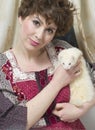 Classic retro style fashion portrait of young pin-up girl holding white weasel pet. American style