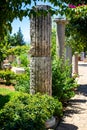 Classic Roman columns in the garden. A picturesque alley with antique decorations. The architecture of ancient Rome Royalty Free Stock Photo