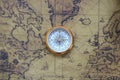 Classic round compass on background of old vintage map of world Royalty Free Stock Photo