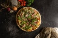 Classic round thin crust pizza with bacon, arugula and grated parmesan cheese. Pizza, vegetables and herbs