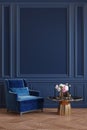 Classic royal blue interior with armchair, coffee table, flowers and wall moldings.