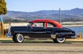 Classic 1950s Chevrolet Fleetline DeLuxe car in two-tone black and red outdoors in California