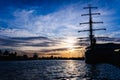 A classic sailboat moored to port in a beautiful sunset