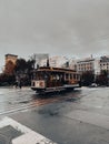 Classic San Francisco trolley car on a rainy day, surrounded by a vintage cityscape