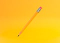 Classic sharp wooden pencil with rubber eraser flying on yellow background