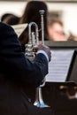 Classic silver trumpet in an orchestra. Sheet of musical notes in the background out of focus