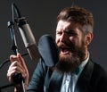 Classic singer is performing a song with a microphone while recording in a music studio. Royalty Free Stock Photo