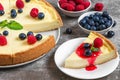 Classic sliced New York cheesecake with fresh berries and jam on stone background, close up Royalty Free Stock Photo