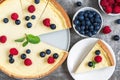 Classic sliced New York cheesecake with fresh berries and mint on stone background, top view Royalty Free Stock Photo