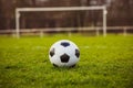 Classic soccer ball in sunset  with typical black and white pattern, placed on stadium turf. Traditional football ball on the Royalty Free Stock Photo