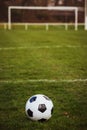 Classic soccer ball  with typical black and white pattern, placed on stadium turf. Traditional football ball on the green grass Royalty Free Stock Photo