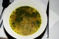 Classic Soup au pistou pesto in a white bowl being served in a restaurant. traditional authentic