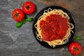 Spaghetti pasta with tomato sauce, peppers and mushrooms, above view on a dark stone background Royalty Free Stock Photo