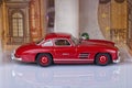A classic sports car of the year 1954 of red color inside a garage made with euro notes