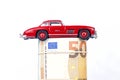 A classic sports car of the year 1954 of red color over euro bills isolated Royalty Free Stock Photo