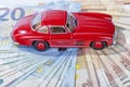 A classic sports car of the year 1954 of red color over euro bills