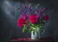 Classic still life with beautiful purple peony and lupin flowers bouquet in white jug. Art photography