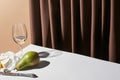 Classic still life with Camembert cheese, white wine and pear on table near curtain isolated on beige Royalty Free Stock Photo