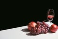 Classic still life with fruits and red wine on white table isolated on black Royalty Free Stock Photo