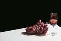 Classic still life with grape and red wine on white table isolated on black Royalty Free Stock Photo