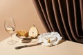 Classic still life with pear, white wine and Camembert cheese on table near curtain isolated on beige Royalty Free Stock Photo