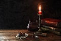 Classic still life with vintage books and candle with a glass of red wine and chocolate