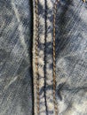 A classic stitch on blue vintage shabby jeans closely. Royalty Free Stock Photo