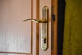 Classic style brown door. Opened white door to the bathroom. Classic brown door with golden handle. Close-up. Royalty Free Stock Photo