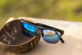 Classic sunglasses model with blue lenses and black frame shoot in a summer day closeup . Selective focus