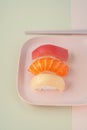 Classic sushi nigiri on a plate on a pink background