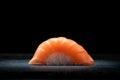 Classic sushi nigiri with salmon on a dark stone background