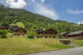 Classic swiss chalet in the middle of green alpine meadows . Cozy rural village Champery in Switzerland. Bright blue sky and white Royalty Free Stock Photo