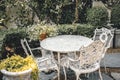 Classic table set in the garden. Vintage luxury victorian style mable stone table chair at outdoor gothic garden backyard summer Royalty Free Stock Photo