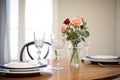 classic table setting with crystal stemware, fine porcelain, and a rose bouquet Royalty Free Stock Photo