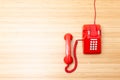 Classic red telephone on wooden desk Royalty Free Stock Photo