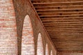 Detail of an arched brick structure with exposed wooden beam rafters