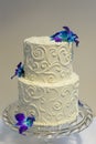 Classic 2 tier wedding cake with buttercream piping and floral accents.