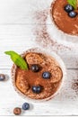 Classic tiramisu dessert with blueberries, mint in white jar on grey background. Flat lay concept. Vertical Royalty Free Stock Photo