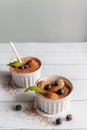 Classic tiramisu dessert with blueberries, mint in white jar on grey background. Flat lay concept. Vertical Royalty Free Stock Photo