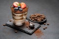 Classic tiramisu dessert with blueberries and strawberries in a glass on stone serving board on dark concrete background Royalty Free Stock Photo