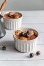 Classic tiramisu dessert with blueberries in white jar on grey background. Vertical Royalty Free Stock Photo