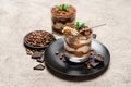 Classic tiramisu dessert in a glass cup and pieces of chocolate on concrete background Royalty Free Stock Photo