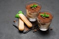 Classic tiramisu dessert in a glass and savoiardi cookies on dark concrete background Royalty Free Stock Photo