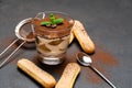 Classic tiramisu dessert in a glass and savoiardi cookies on dark concrete background Royalty Free Stock Photo